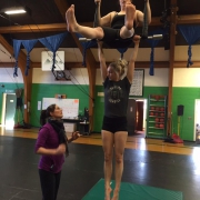 photo of two ProTrack Program students training with a coach on duo trapeze